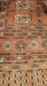 A Bokhara rug, the central panel set with two rows of elephant foot medallions,