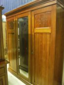 A late Victorian walnut triple wardrobe compactum with central mirrored door CONDITION