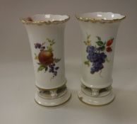 A pair of 19th Century Meissen cylindrical stem vases with flared rims and scroll feet on a