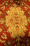 A Caucasian rug the central panel set with a floral decorated medallion on a red floral decorated