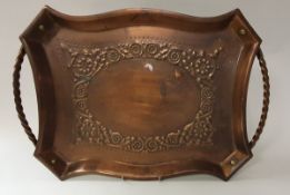 An Arts & Crafts style copper twin-handled tray with embossed scrolling foliate decoration,