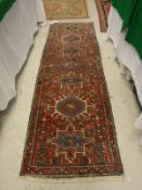 A Persian Karaja runner the central panel set with repeating geometric patterned medallions the