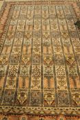 A Persian carpet, the central panel set with tiled design and each tile with floral motifs,