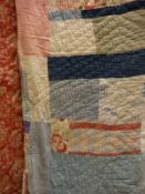 An early 20th Century patchwork quilt in pink and blue hues together with three middle eastern