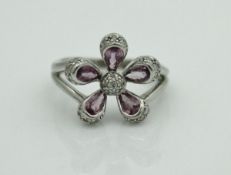 A 9 carat white gold amethyst and diamond chip ring in the form of a flower head, size Q, approx 4.