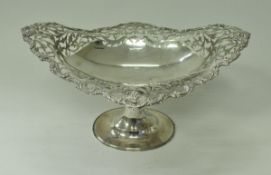 An Edwardian silver pedestal dish with pierced foliate decorated bowl on a spreading oval foot (by