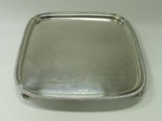 A George V silver salver of rounded square form,