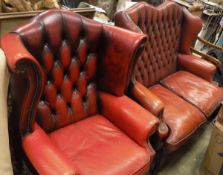 A modern red leather buttoned upholstered wing back scroll arm chair,