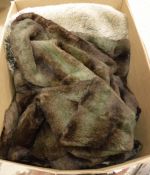 A box containing fake fur throws and cushions