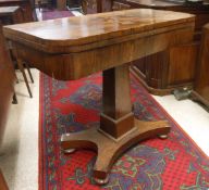 A Victorian rosewood fold over card table on pedestal platform base