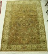 A Persian style carpet, the central panel set with all over floral decoration on a mustard ground,