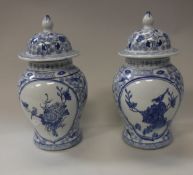 A pair of modern Chinese blue and white lidded vases with stylised floral and bird decoration