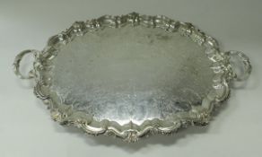 A large silver plated tray in the Rococo taste with all-over scrolling foliate engraved and cast