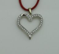 A 9 carat yellow and white gold pendant in loveheart shaped form, set with diamonds, approx 1.