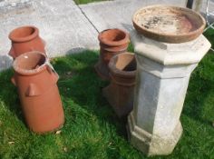 A large pale terracotta octagonal chimney pot with four further terracotta chimney pots