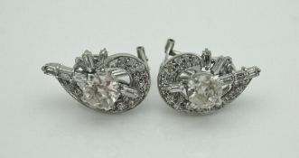 A pair of 18 carat white gold earrings, the central stones approx 1 carat each,