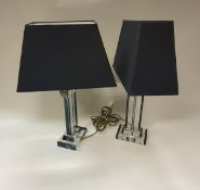 A pair of glass and black glass based table lamps in the Art Deco style and a pair of perspex