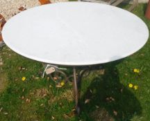 A modern circular table with granite top and wrought iron tripod based