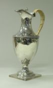 An Edwardian silver water jug with caned handle and beaded decoration,