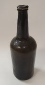 An 18th Century dark green/black glass wine bottle,