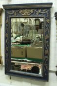 A blue and gilt painted oak framed wall mirror with carved grape and vine decoration