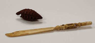 A carved nut ojimi bead as a sampan style boat together with a bone stanhope enclosing image of