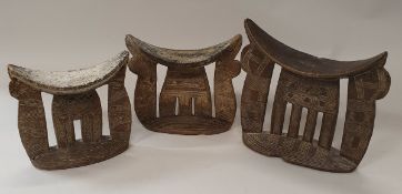 A collection of three African tribal carved wooden headrests