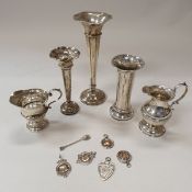 A collection of silverware comprising two cream jugs both with scrolling handles and circular step