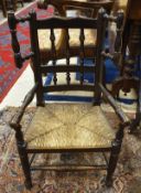 A 19th Century oak spindle back child's chair with turned wings and rush seat the base untied by