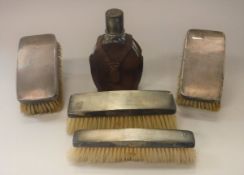 A set of four silver backed hairbrushes with engine turned decoration and initialled "NCT",