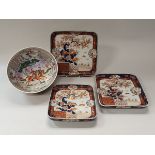 A graduated set of three Japanese Imari square dishes decorated with birds amongst blossoming