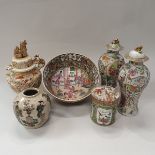 A pair of 19th Century Chinese famille rose baluster shaped vases and covers with all over panel