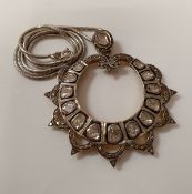 A large pendant of circular form set with fourteen larger old cut diamonds and others