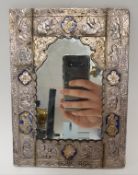 A Persian white metal mounted mirror with embossed decoration of figural scenes and further