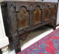 An 18th Century oak coffer, the plain top over a carved four panel front, dated 1778,
