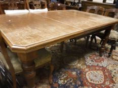 A Victorian oak extending dining table with extra leaf raised on ringed and turned supports