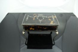 A George V silver mounted tortoiseshell dressing table box raised on cabriole legs (London 1912 by