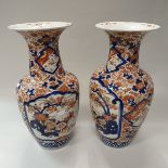 A pair of Japanese Meiji period Imari vases with all over foliate decoration and panels of