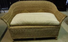 A modern wicker two seat sofa and two matching chairs