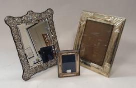 A modern silver framed mirror with easel back and foliate decoration together with a white metal