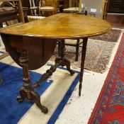 A Victorian burr walnut veneered oval drop leaf Sutherland table on carved end pillar supports to