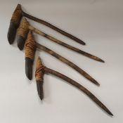 A collection of four Dani palm wood handled axes with raffia bound stone heads/blades (west Papua