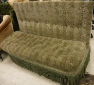 A modern banquette with spotted green upholstery