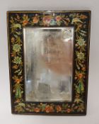 An early 20th Century Persian mirror with floral painted frame and bevel edged plate,