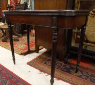A 19th Century mahogany fold-over card table on turned and reeded legs