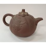 A Chinese Yi Xing terracotta teapot of squash form with leaf relief decoration bearing flower head