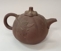 A Chinese Yi Xing terracotta teapot of squash form with leaf relief decoration bearing flower head