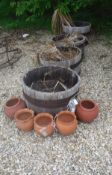 A collection of various terracotta and coopered oak garden pots/urns and four coopered barrel tubs