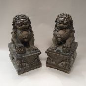 A pair of Chinese bronze dogs of Fo or temple lions, one seated his right foot upon a ball,