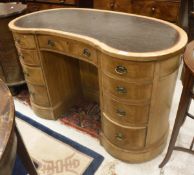 A Victorian walnut kidney shaped desk the leather top above two banks of four drawers and central